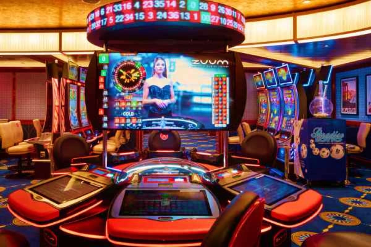Casino gaming room on Costa Smeralda cruise ship with roulette wheel, slot machines, and red seating